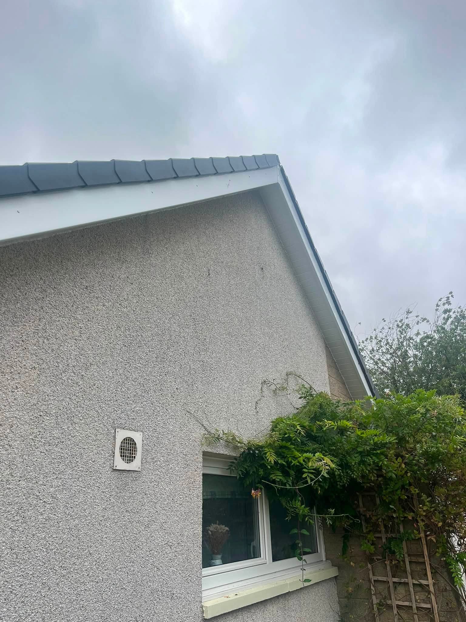 New guttering and bargeboard along a gable end above a window and vent
