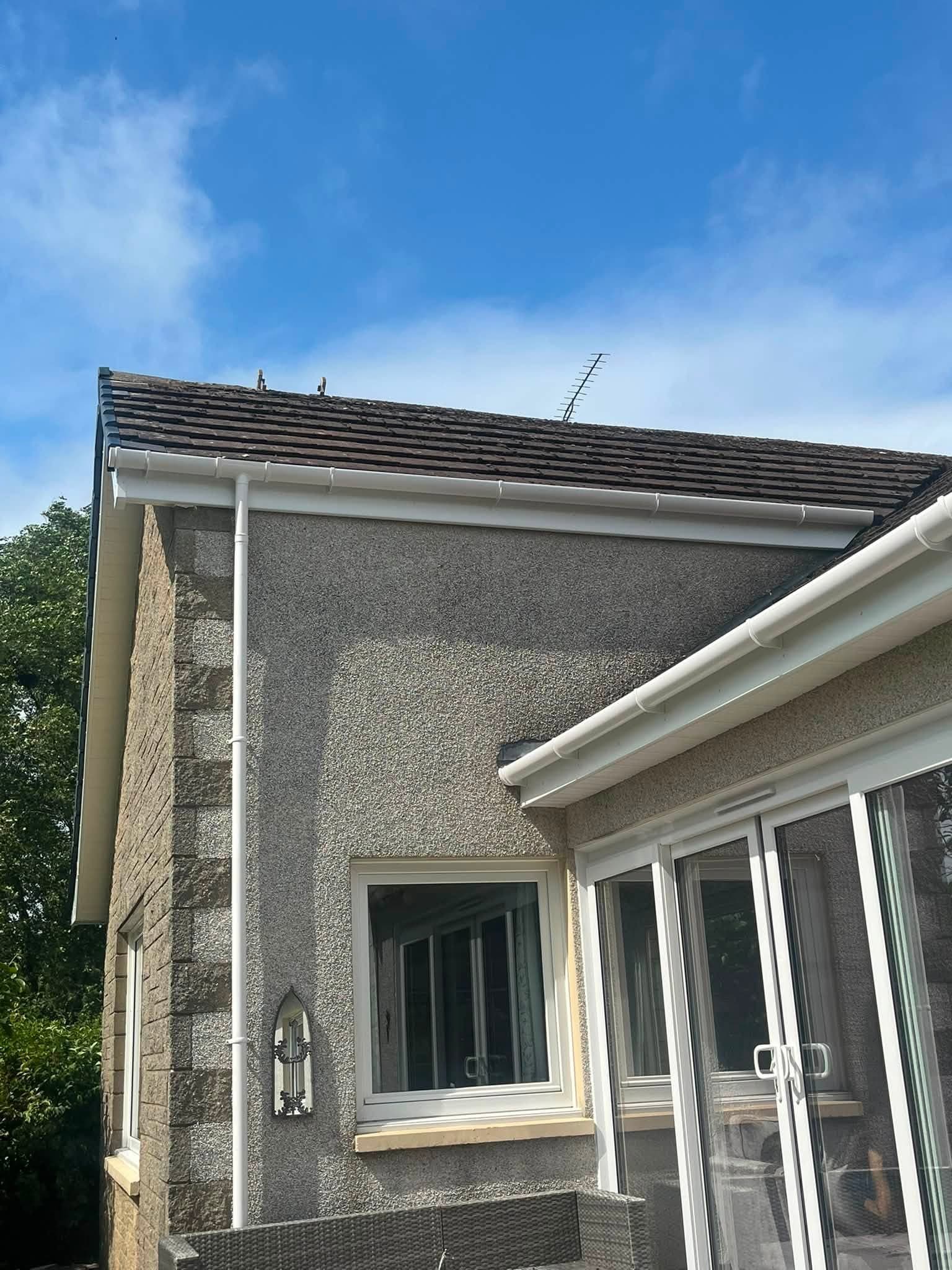 New guttering and fascia fitted around a gable end and conservatory roof