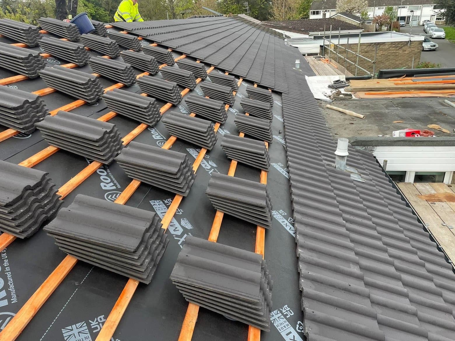 RML roofer at work replacing concrete tiles over fresh battens and membrane