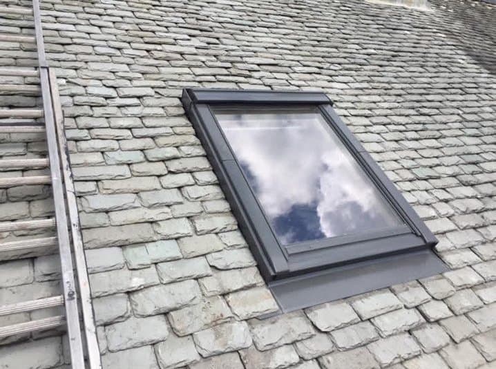 Slate roof with a newly fitted roof window and lead flashing